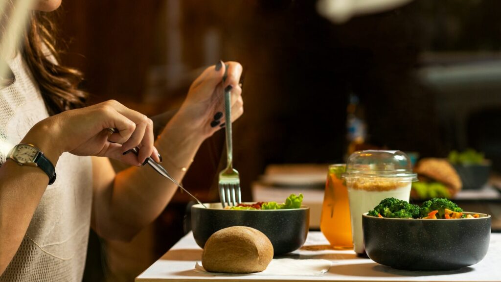 Woman sitting at a table eating salad and autumn vegetables in Orland Park, Illinois.